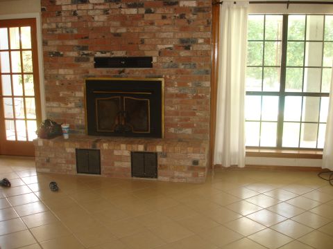 1989 Ford Bronco - This interior scene shows a brick fireplace and a large window with a view of trees outside.