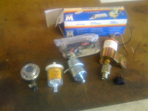 1994 Ford Bronco - A collection of automotive fuel system components, including filters and a fuel pump, are displayed on a table.