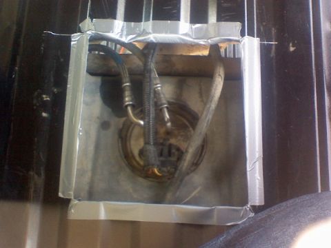1993 Ford Bronco - Fuel pump assembly with hoses, secured with tape and wood, is visible in this close-up.