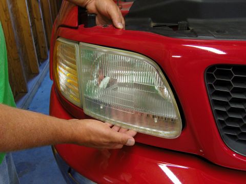 2007 Ford Mustang - Headlight assembly removal on a red truck.