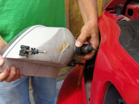 2007 Ford Mustang - A person is shown removing the headlight assembly from a red vehicle, likely for repair or replacement.