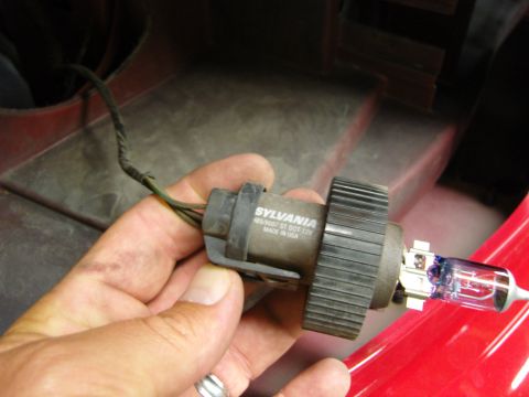 2007 Ford Mustang - A Sylvania headlight bulb assembly is held in a hand, showing the part number and 'Made in USA'.