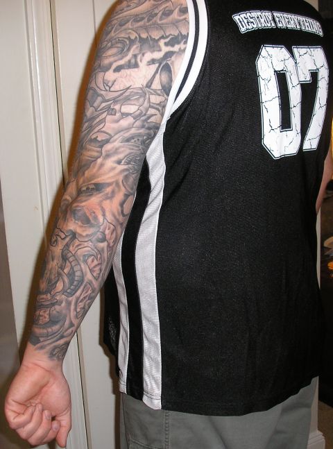 1995 Ford Bronco - Full arm tattoo mechanical elements and a skull design. Man wears a jersey with 'Destroy Everything' and '07'.