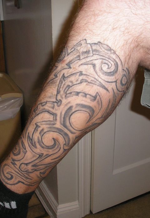 1995 Ford Bronco - A person's leg displays a large tribal tattoo with swirling patterns and sharp edges.