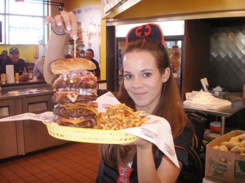 1989 Ford Bronco - A woman presents a towering burger and a basket of fries, likely a restaurant promotion.