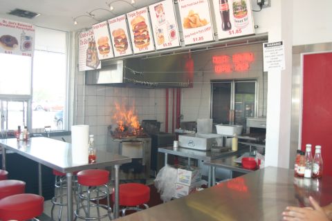 1989 Ford Bronco - Grill fire erupts in the kitchen of a burger restaurant, with menu boards visible overhead.