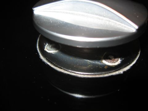 1968 Shelby GT500 - A close-up view of a hood pin rivet, showing its metallic texture and surrounding mounting area.