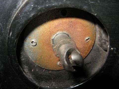 1968 Shelby GT500 - Close-up view of a rusted metal shaft and plate assembly, likely a component from machinery.