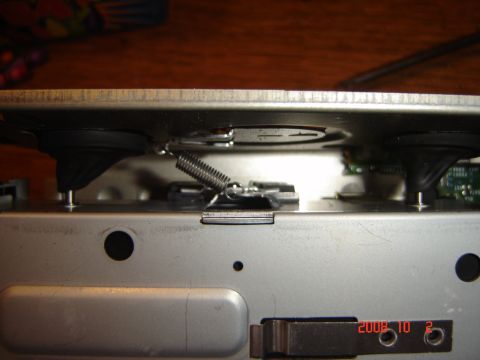 1993 Ford Bronco - The internal workings of a CD changer are visible, showing a spring mechanism and rubber dampeners.