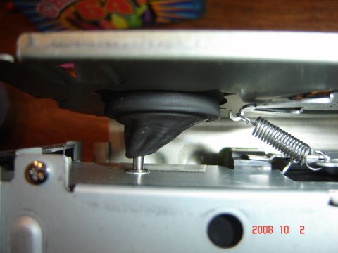 1993 Ford Bronco - Close-up view of a CD changer mechanism, showing a rubber damper and a metal spring.