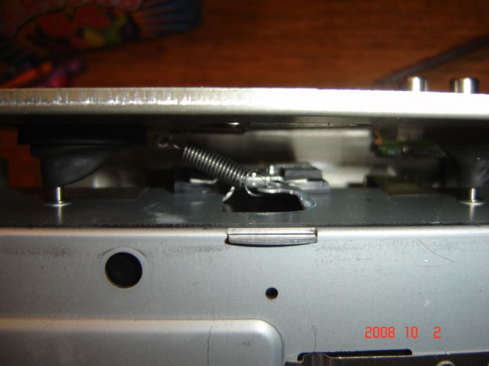 Internal view of a mechanism with a spring and metal components. Date stamp reads 2008 10 2