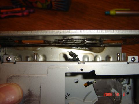 1993 Ford Bronco - The internal mechanism of a car stereo CD changer shows signs of damage, possibly from heat.