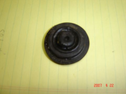 1993 Ford Bronco - A single black rubber grommet is shown against a yellow background.