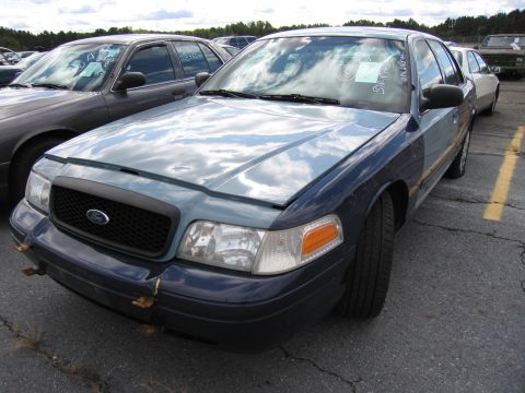1991 Ford LTD Crown Victoria - A blue and gray Ford Crown Victoria is parked in an outdoor lot with other vehicles.