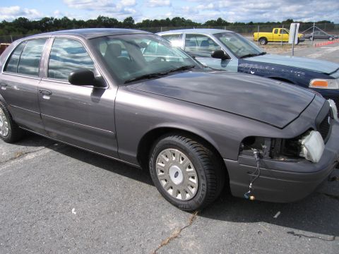 1991 Ford LTD Crown Victoria - A gray Ford Crown Victoria is parked outside, showing damage to the front passenger side headlight assembly.