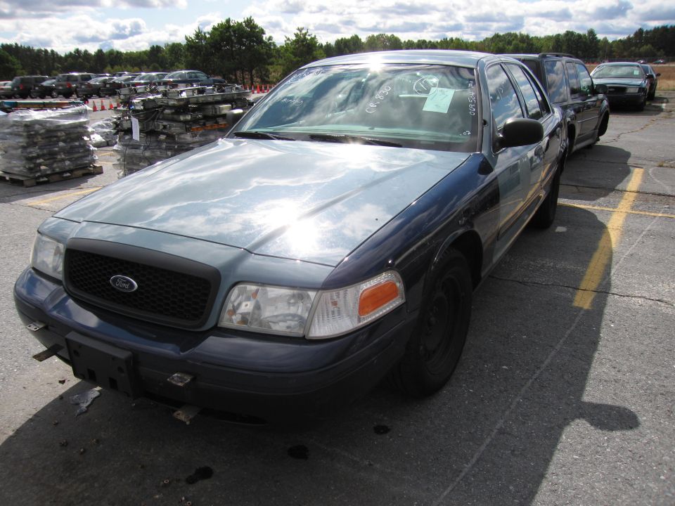 Dark blue and gray Ford Crown Victoria with a black grille and clear headlights