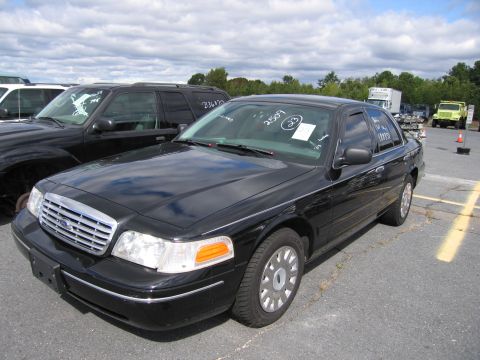 1991 Ford LTD Crown Victoria - A black Ford Crown Victoria sedan is parked in an outdoor lot with other vehicles.