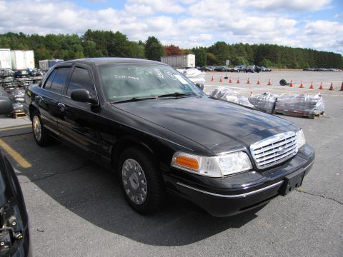 1991 Ford LTD Crown Victoria - Black sedan with text written on the windshield, seen from a front quarter angle in an outdoor lot.