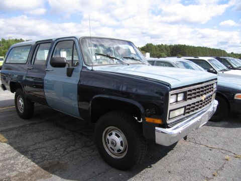 1991 Ford LTD Crown Victoria - This two-tone SUV is parked in a lot with other vehicles. The front quarter view shows its distinctive color combination.