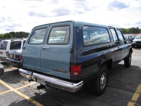 1991 Ford LTD Crown Victoria - Rear view of a two-tone 1991 Chevrolet Suburban parked outdoors.