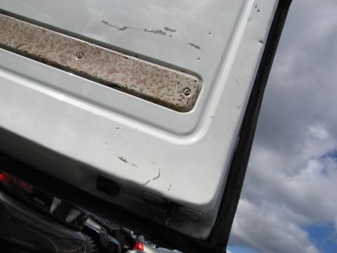 1991 Ford LTD Crown Victoria - Door jamb detail on a white vehicle, showing wear and rust on the trim piece.