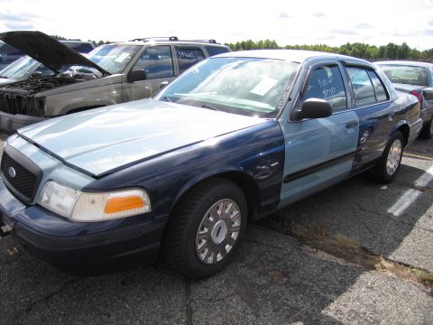 1991 Ford LTD Crown Victoria - This two-tone sedan, likely a Ford Crown Victoria from the early 2000s, is parked in a lot with other vehicles.