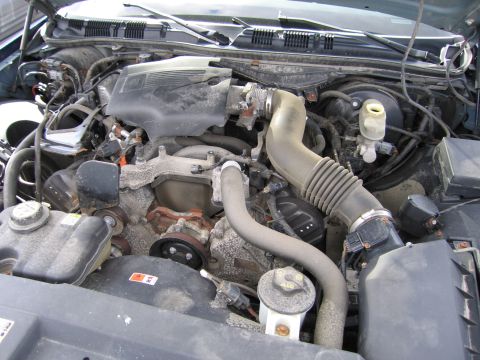 1991 Ford LTD Crown Victoria - Close-up of a dusty engine bay showing various components and hoses.