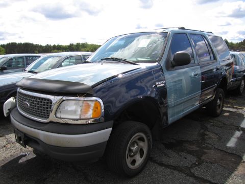 1991 Ford LTD Crown Victoria - This Ford Expedition has a light blue hood and front fender, contrasting with the dark blue body. Other vehicles are visible in the backgro…