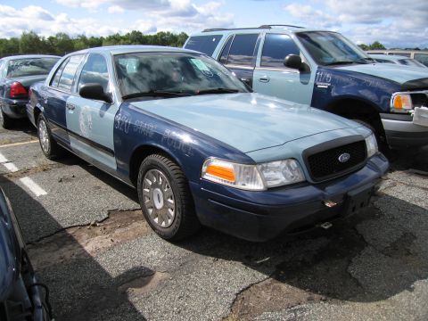 1991 Ford LTD Crown Victoria - Ford Crown Victoria police car, likely from the early 2000s, parked next to an SUV.