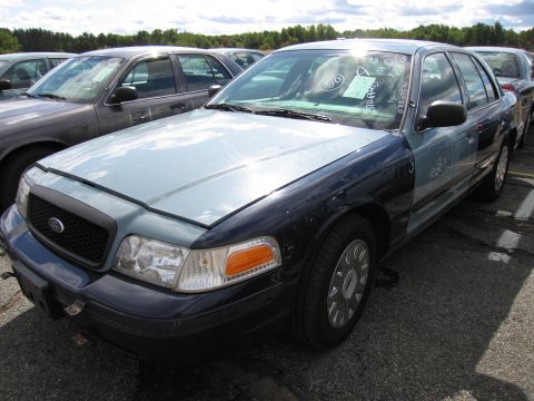 1991 Ford LTD Crown Victoria - A two-tone Ford Crown Victoria is parked in a lot with other vehicles.
