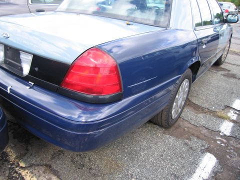 1991 Ford LTD Crown Victoria - The rear of a blue Ford Crown Victoria is visible, showing its taillight and part of the trunk.