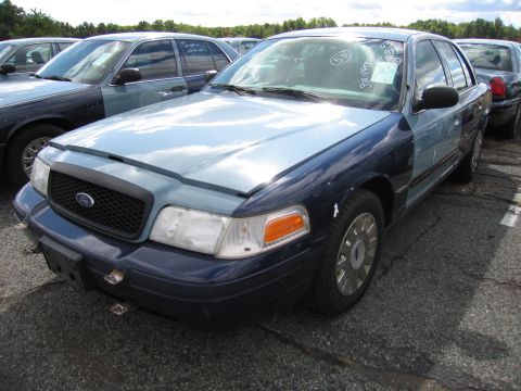 1991 Ford LTD Crown Victoria - A two-tone blue sedan is parked in a lot with other vehicles. Text on the windshield indicates "03 97K".