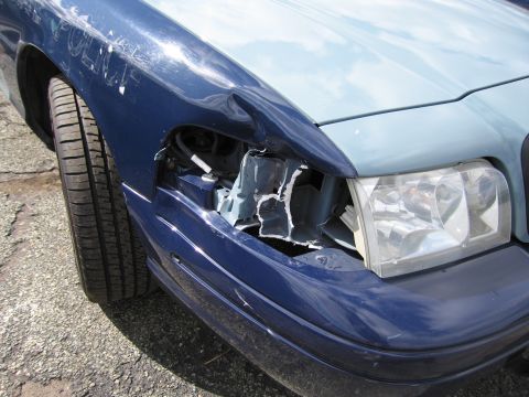 1991 Ford LTD Crown Victoria - A damaged blue and light blue car shows a crumpled front fender and missing headlight assembly.