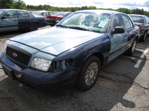 1991 Ford LTD Crown Victoria - Ford Crown Victoria in a lot, showing damage and markings on the windshield.