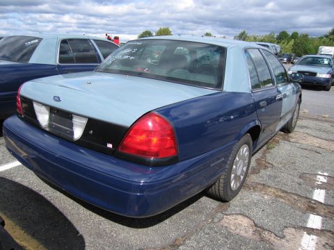 1991 Ford LTD Crown Victoria - A two-tone blue and light blue sedan, possibly a Ford Crown Victoria, is parked outdoors with other vehicles visible.