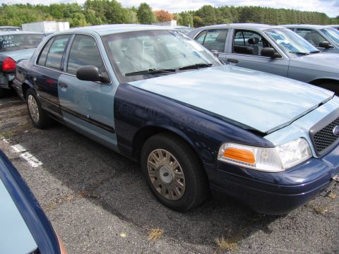 1991 Ford LTD Crown Victoria - A two-tone Ford Crown Victoria is parked in a lot with other vehicles.