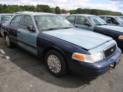 1991 Ford LTD Crown Victoria - Two-tone Ford Crown Victoria parked in a lot with other similar vehicles.
