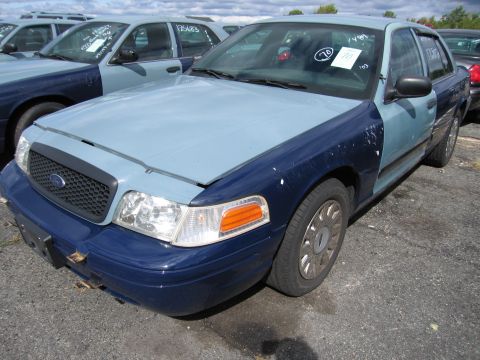 1991 Ford LTD Crown Victoria - A two-tone Ford Crown Victoria is parked in a lot with other similar vehicles.