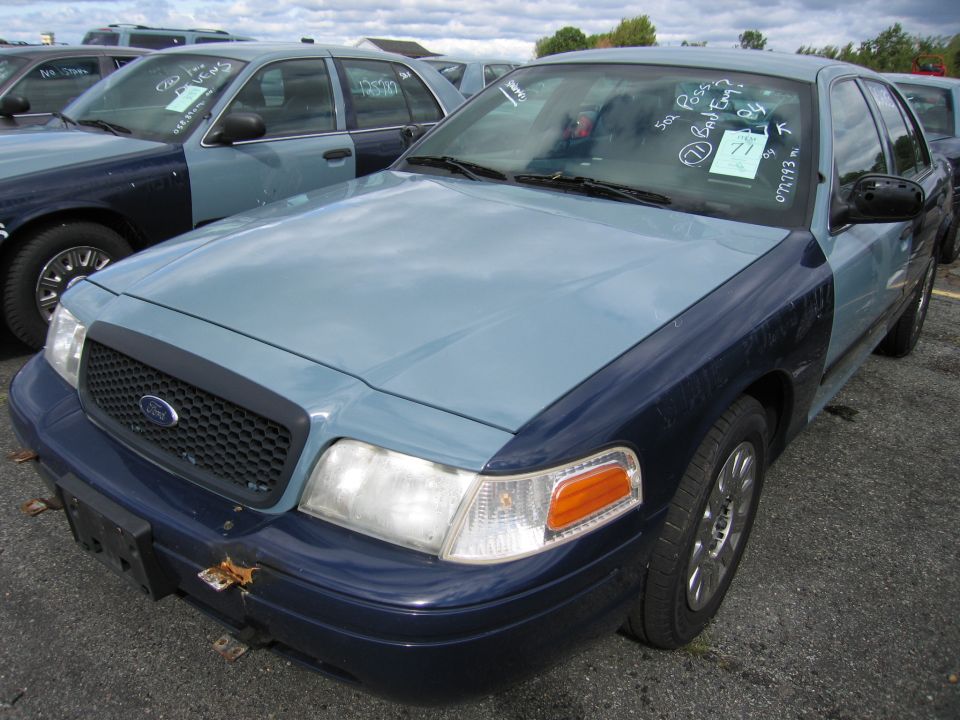 Ford Crown Victoria with two-tone paint, parked in a lot with other similar cars