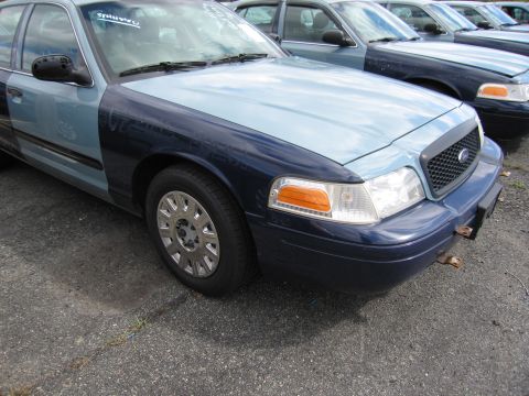1991 Ford LTD Crown Victoria - A two-tone Ford Crown Victoria is parked in a lot with other vehicles.
