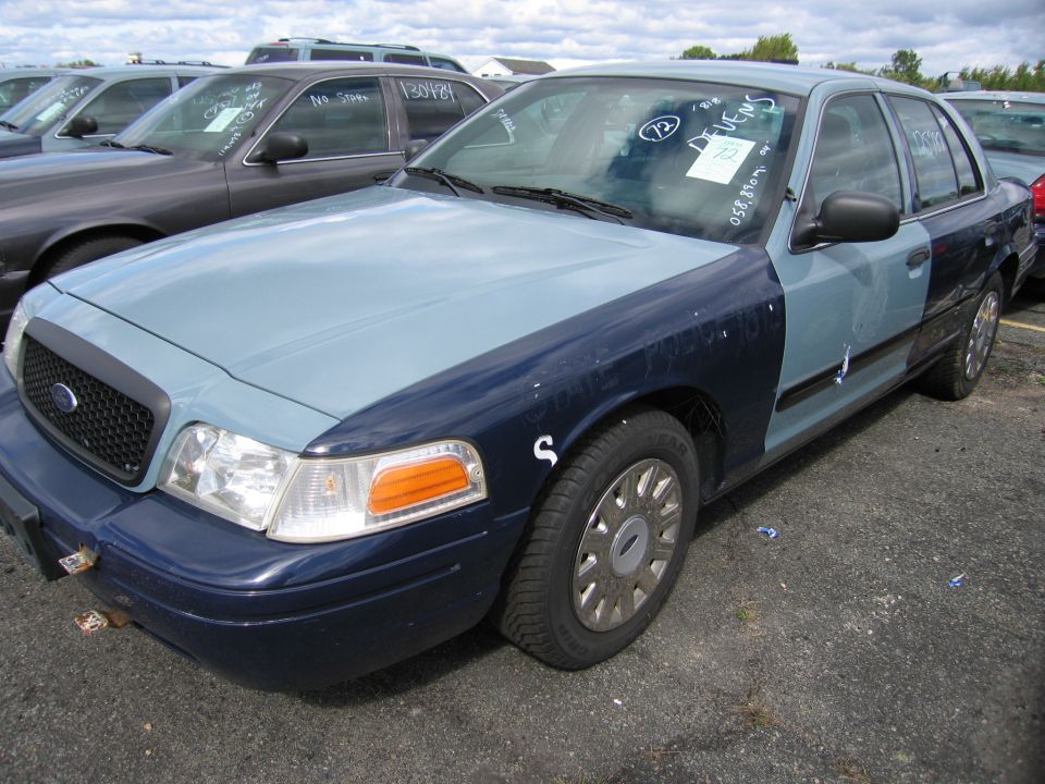 Two-tone police car, front quarter view. Visible text on windshield