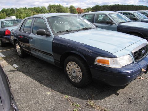 1991 Ford LTD Crown Victoria - This Ford Crown Victoria has a two-tone paint scheme and is parked in a lot with other vehicles.