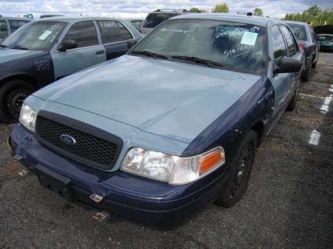 1991 Ford LTD Crown Victoria - Two-tone Ford Crown Victoria parked in a lot with other vehicles. Text is visible on the windshield.