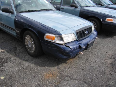 1991 Ford LTD Crown Victoria - Two Ford Crown Victorias are parked side-by-side, one with a damaged front bumper.