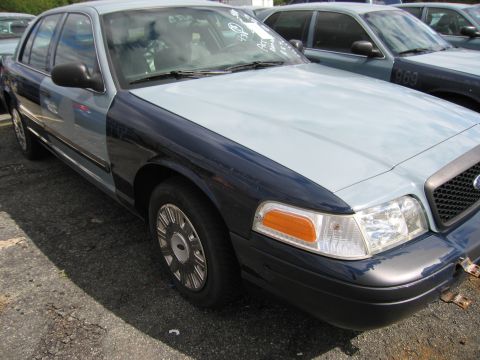1991 Ford LTD Crown Victoria - A two-tone Ford Crown Victoria is parked on asphalt, with another vehicle visible behind it.