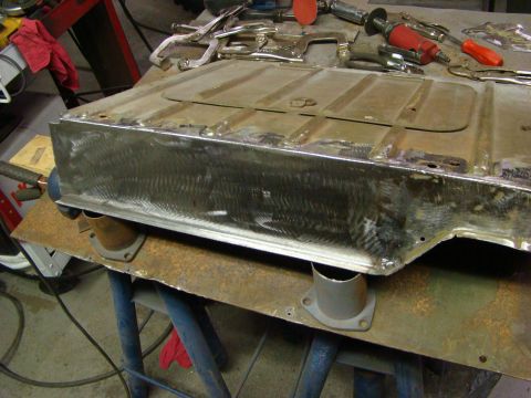 1948 Jeep Wrangler - Car floor pan undergoing repair work with various tools and clamps visible.