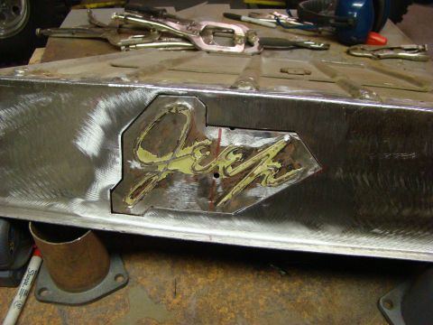 1948 Jeep Wrangler - Close-up of a Jeep logo being worked on, suggesting a body repair or customization project.