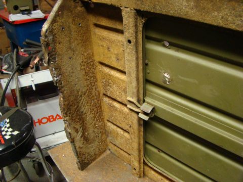 1948 Jeep Wrangler - Close-up of a rusted metal panel, possibly from a vehicle body, showing structural details and a latch.