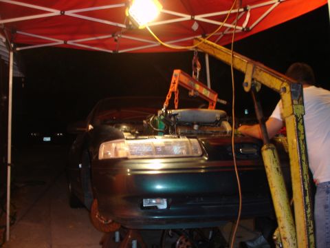 1993 Ford Taurus - Engine removal in progress on a 1993 Ford Taurus, supported by jack stands.