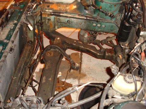 1993 Ford Taurus - The engine bay of a car is shown with the radiator and suspension parts exposed, indicating it is undergoing repairs.